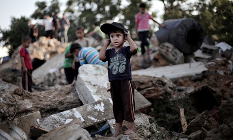 A Palestinian boy plays in the rubble of a home wrecked in an Israeli air raid on Beit Hanoun, Gaza